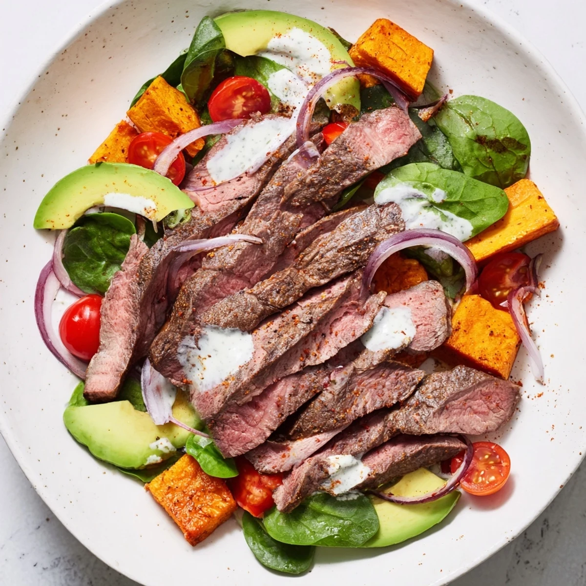 A delicious Beef Avocado Sweet Potato Bowl, showcasing juicy beef, ripe avocado, and a fresh lime dressing.