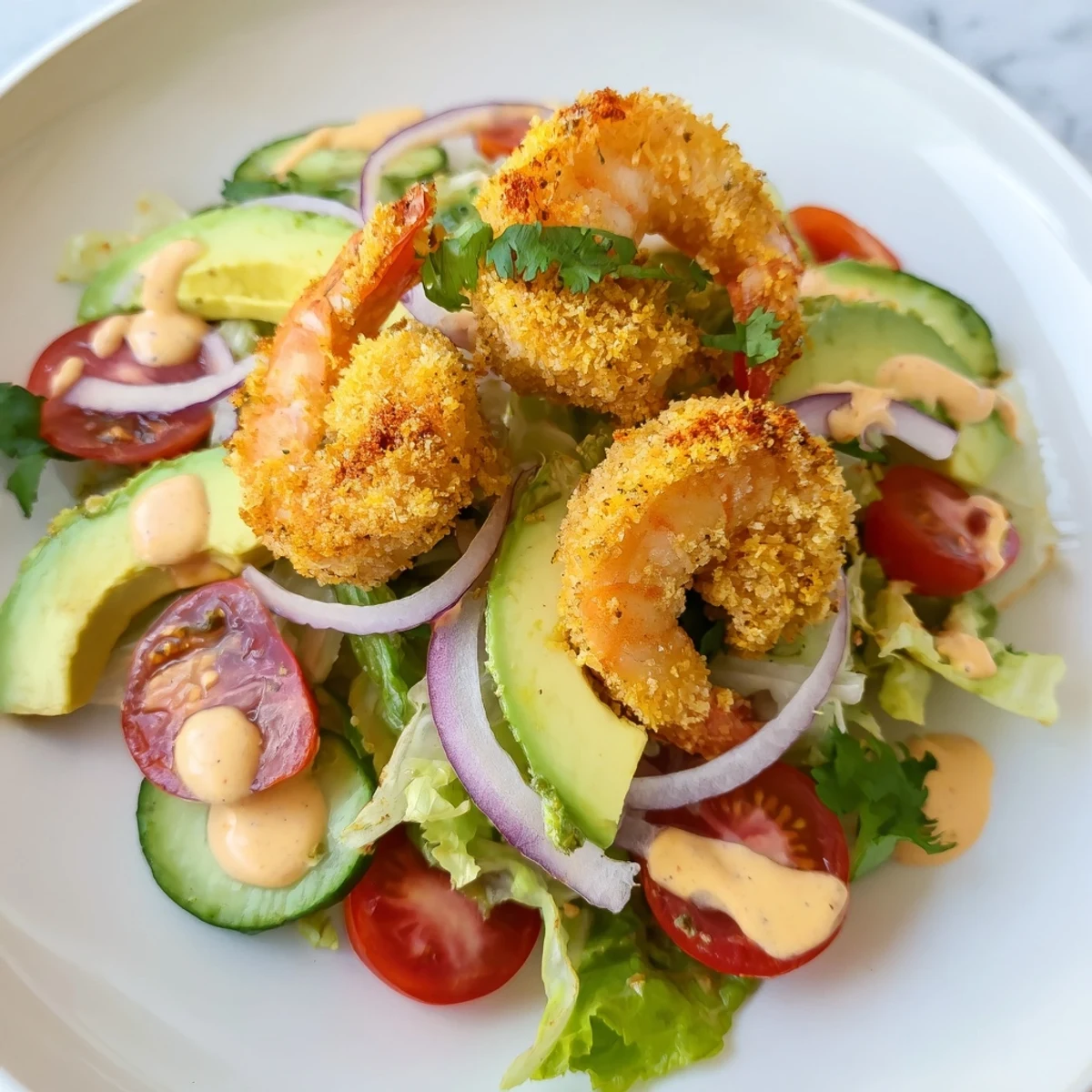 Golden, crispy shrimp sit atop a fresh, vibrant Spicy Crispy Shrimp Salad, ready to eat.