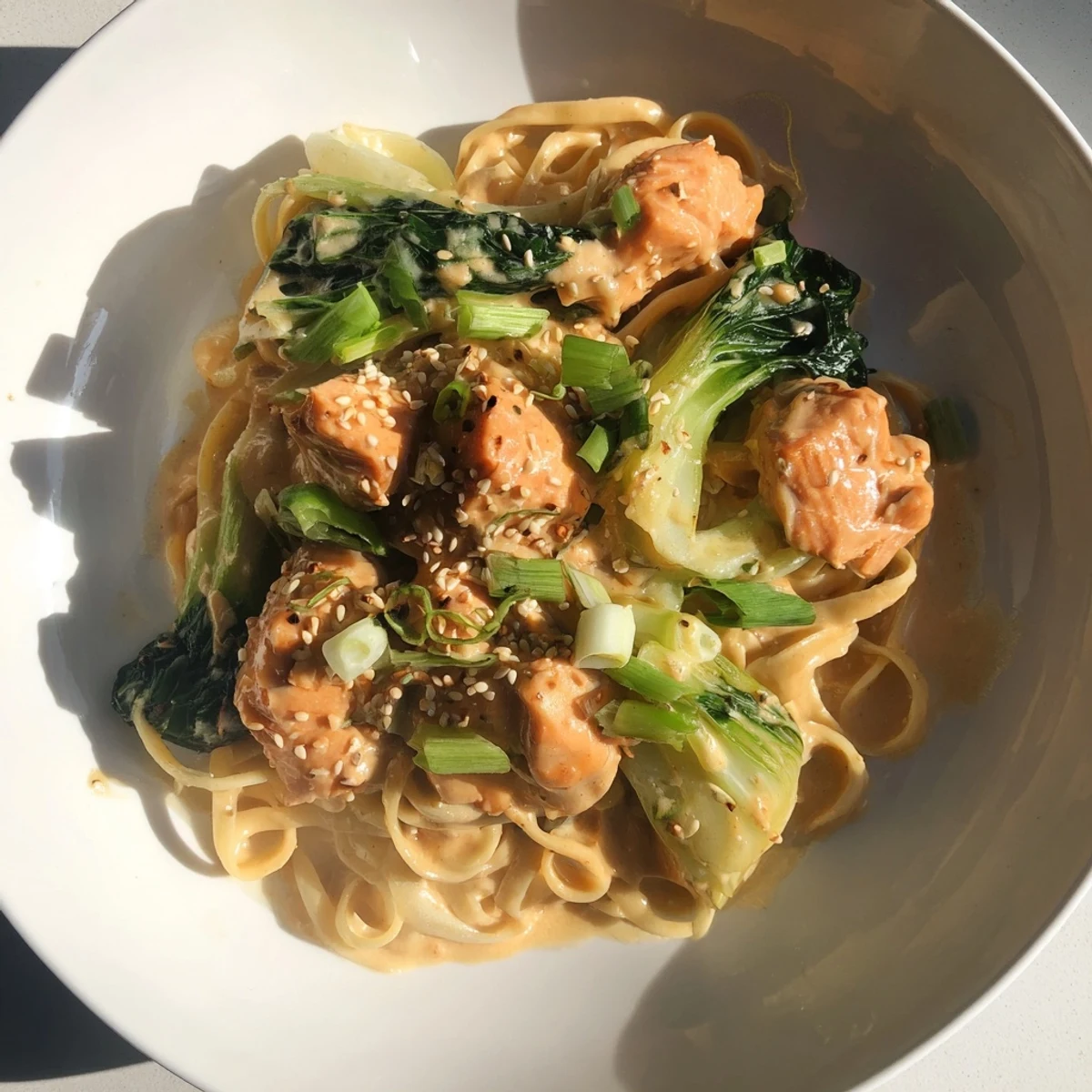 Creamy Miso Butter Salmon Pasta, perfectly plated, garnished with green onions and sesame seeds.