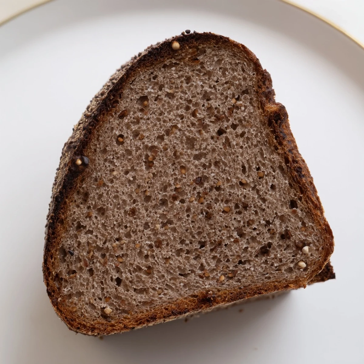 A rustic slice of Estonian Leib sourdough bread, perfectly paired with creamy butter for enjoyment.