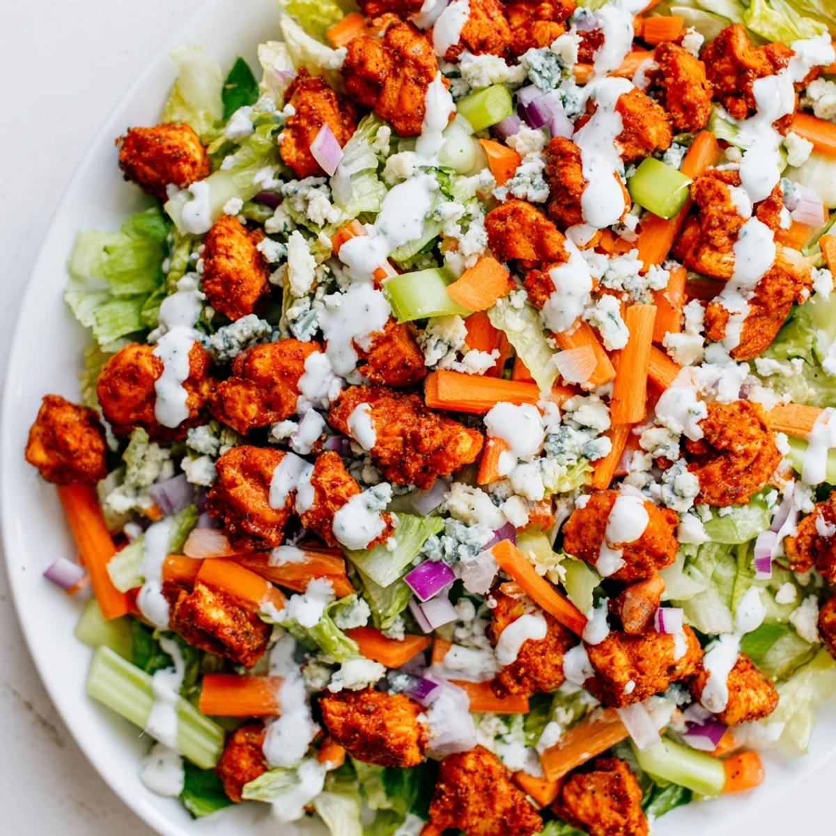 This vibrant Buffalo Chicken Chopped Salad features crisp romaine, spicy chicken, diced celery, and creamy blue cheese crumbles for a satisfying meal.
