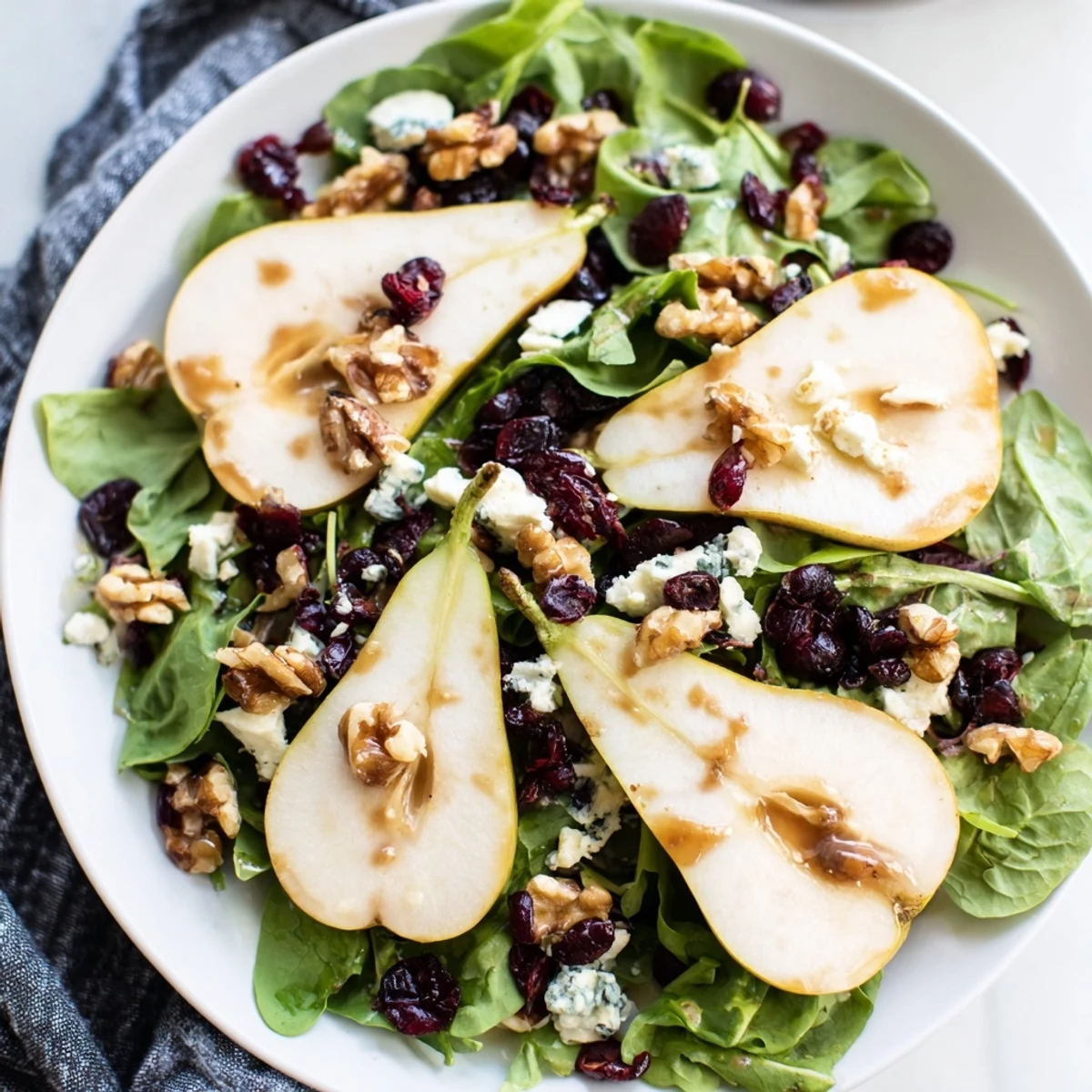 Pear Gorgonzola Salad served as a refreshing appetizer, featuring juicy pear slices and creamy cheese crumbles on fresh greens.