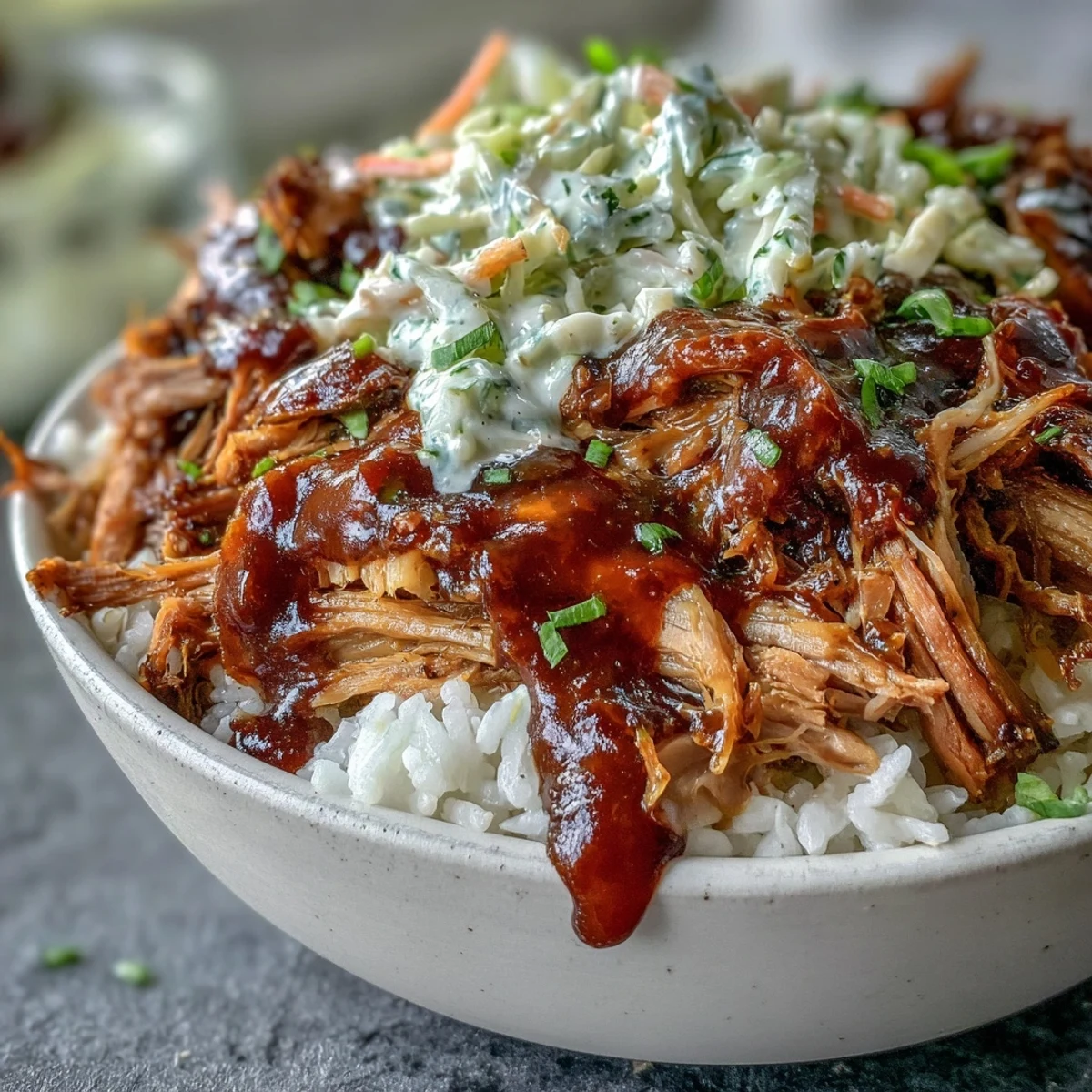 Hearty American Pulled Pork Bowl served with rice, creamy slaw, and a drizzle of rich barbecue sauce.