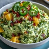 Creamy guacamole with mango and jalapeño, perfect for Cinco de Mayo parties and festive snacking.  