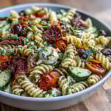 Vibrant pasta salad featuring crisp cucumbers, juicy tomatoes, and creamy mozzarella, tossed in zesty Italian dressing.  