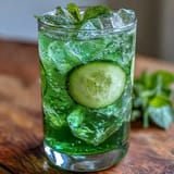 Refreshing Green Detox Cucumber Mint Agua Fresca being poured into a clear glass.