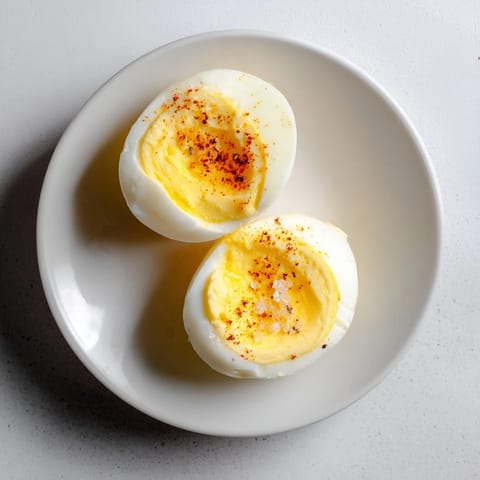 Creamy, perfectly cooked perfect hard-boiled eggs sit in an ice bath after cooking.