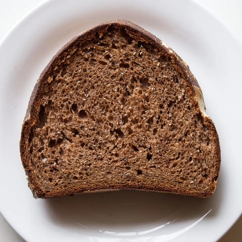 This image shows a freshly baked Latvian Rupjmaize, boasting a rustic texture and rich aroma, ready to serve.