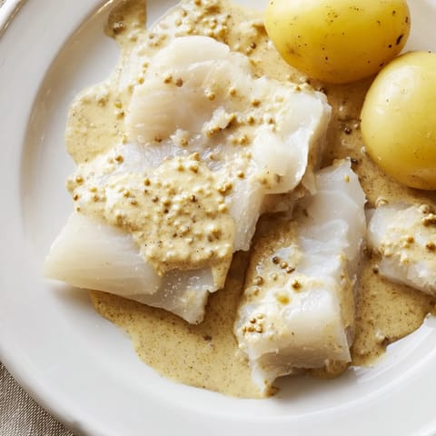 Golden-baked Norwegian Lutefisk, a traditional holiday dish, smothered in rich, flavorful mustard sauce.