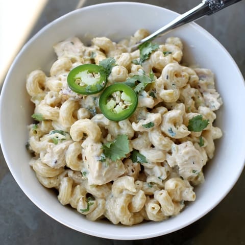 A bowl of Green Chili Chicken Mac with tender chicken, melted Monterey Jack, and mild diced green chiles.