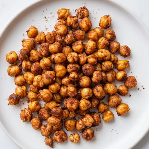 Finger-food bowl of Crispy Chickpea Snack, tossed in warm spices and ready to enjoy as a protein-rich vegan treat.
