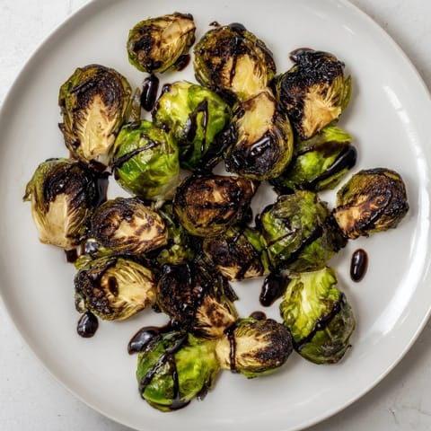 Freshly roasted Brussels sprouts with balsamic glaze, paired with sliced roasted chicken for a complete meal.  