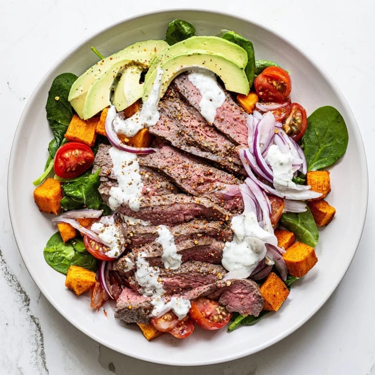 Vibrant Beef Avocado Sweet Potato Bowl overflowing with colorful ingredients and a zesty yogurt dressing.