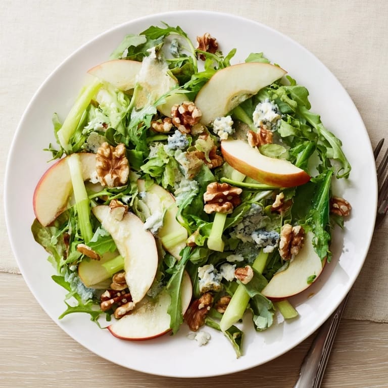 Fresh greens, crisp apple slices, and toasted walnuts tossed in a zesty dressing, showcasing this easy, gluten-free Apple and Walnut Salad.