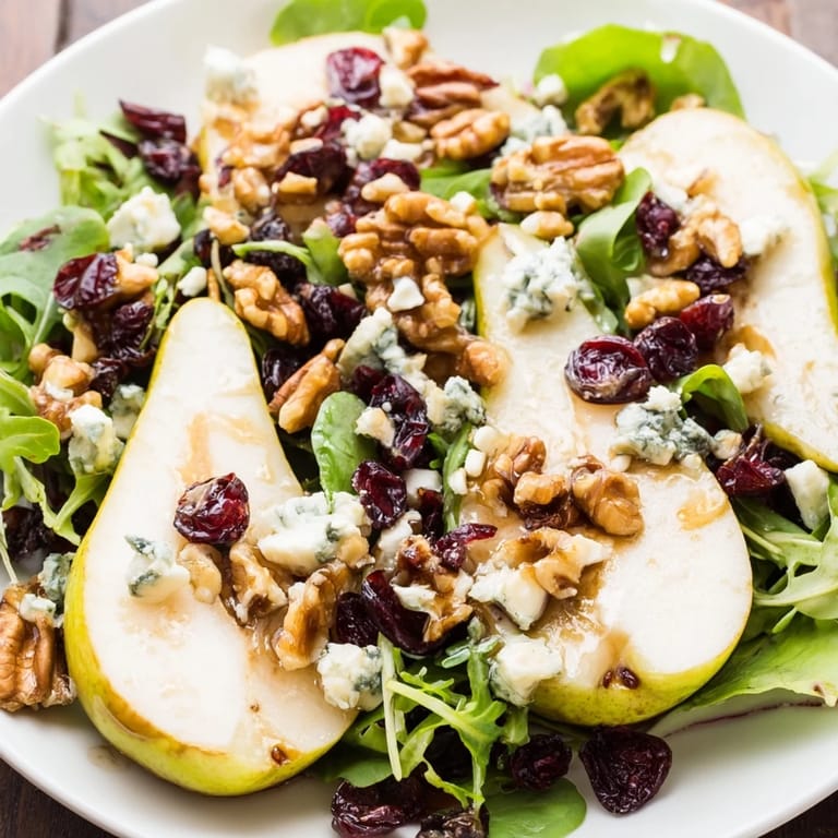 A vibrant salad with sweet pears, tangy Gorgonzola, toasted walnuts, and dried cranberries tossed in a light dressing.